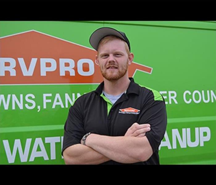 Male Crew Chief Clancy Shelton standing in front of SERVPRO truck